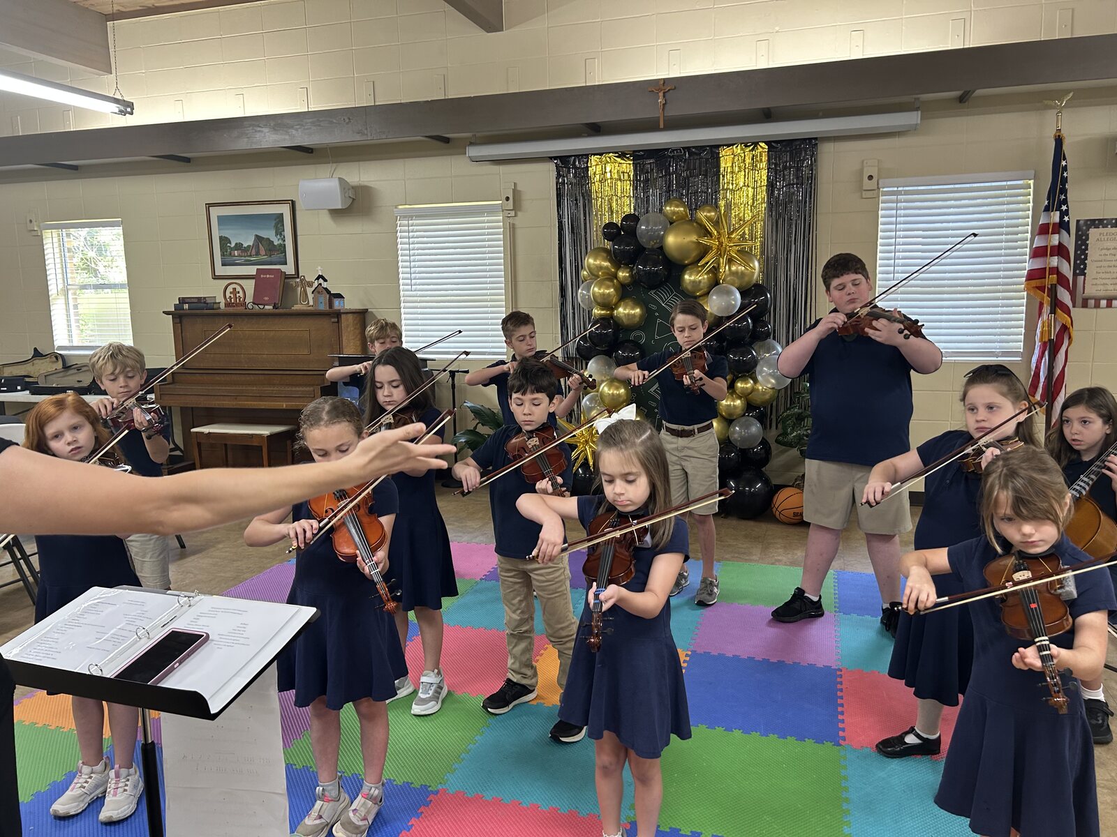 Veritas students practicing violin together with their teacher